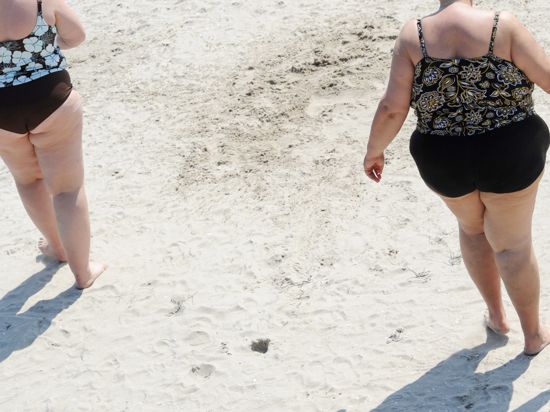 ARCHIV - Zwei übergewichtige Frauen, aufgenommen am 23.05.2010 am Ostseestrand von Binz auf der Insel Rügen. Foto: Stefan Sauer/dpa (zu dpa "Studie: Fettleibige werden in Deutschland ausgegrenzt" vom 21.09.2016) +++ dpa-Bildfunk +++