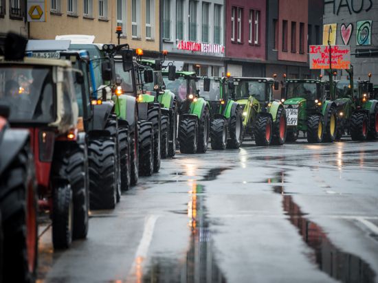 Zahlreiche Traktoren sind auf einer Straße in Siegen zu sehen. Mit einem Konvoi aus mehreren hundert Traktoren haben Landwirte und Landwirtinnen im Raum Siegen am Freitag gegen Einsparläne der Ampel-Koalition protestiert.