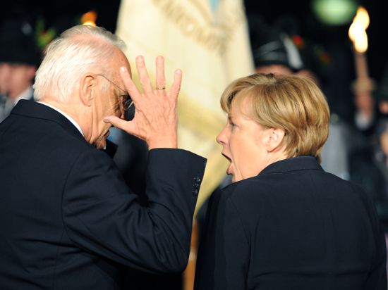 Der frühere bayerische Ministerpräsident Edmund Stoiber (CSU) und die damalige Bundeskanzlerin Angela Merkel (CDU) unterhalten sich 2011 in München vor dem Empfang zu Stoibers 70. Geburtstag im Garten des Prinzregententheaters.