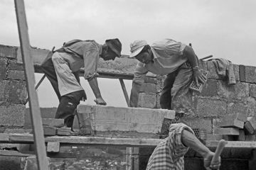 Männer auf der Baustelle eines Hauses im Deutschland der 1950er Jahre.