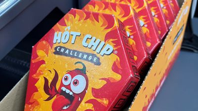 Mehrere Packungen der „Hot Chip Challenge“ liegen bei einem Kiosk neben der Kasse.