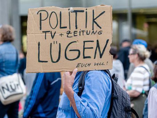 Ein Mann hält ein Plakat mit der Aufschrift « Politik, TV und Zeitung lügen euch voll!». Die Initiative Querdenken 40 demonstriert hier unter dem Motto « Gemeinsam und gewaltfrei für die Aufhebung der Coronamaßnahmen». +++ dpa-Bildfunk +++