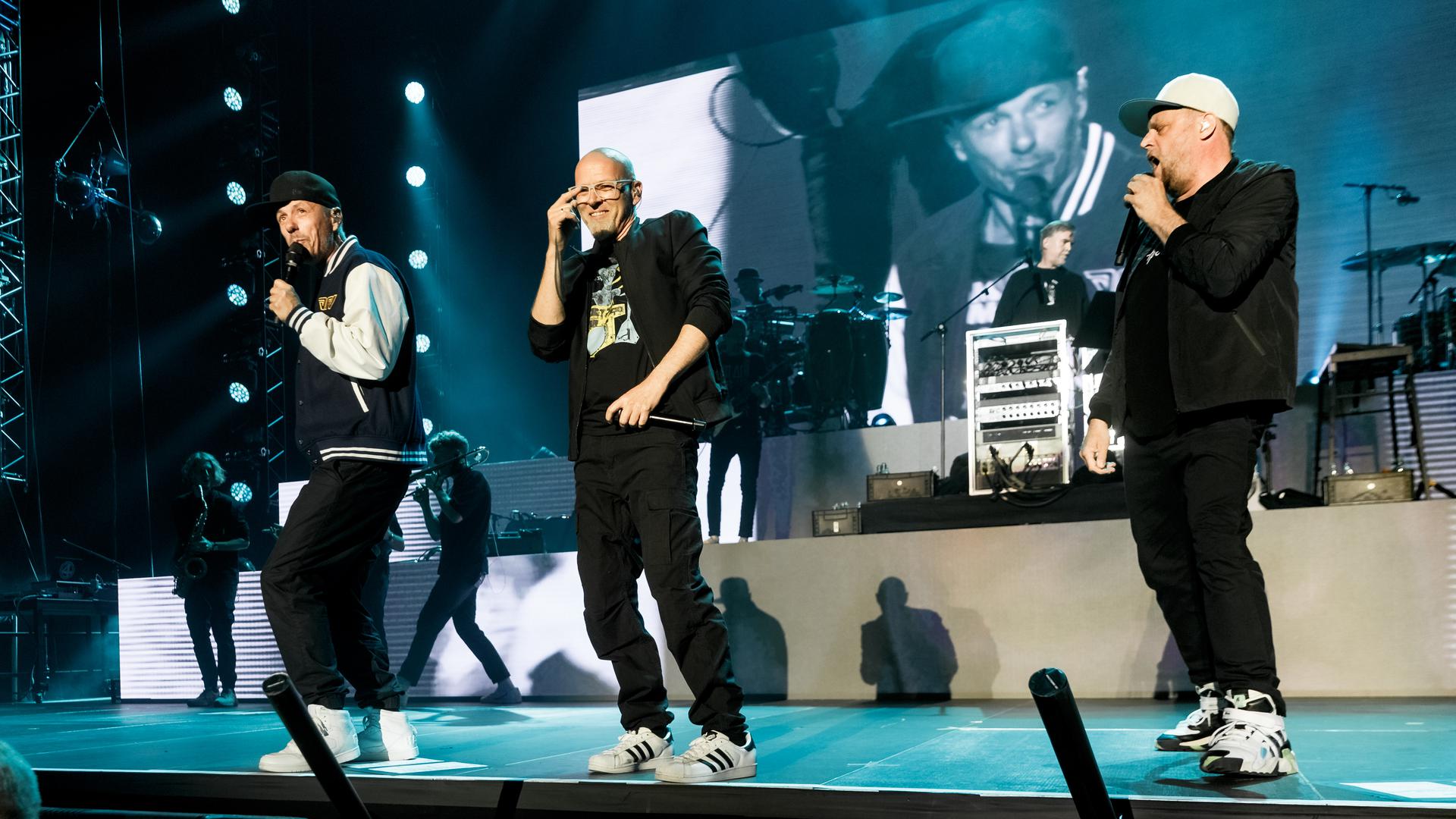 Michi Beck (von links nach rechts), Thomas D und Smudo performen beim Auftakt der Deutschland-Tour der Hip-Hop-Gruppe „Die Fantastischen Vier“. Im Hintergrund ist And.Ypsilon.