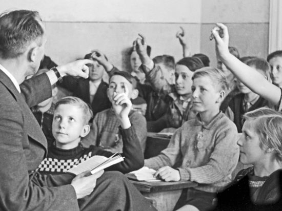 Ein Lehrer unterrichtet eine Schulklasse des Jahres 1949.