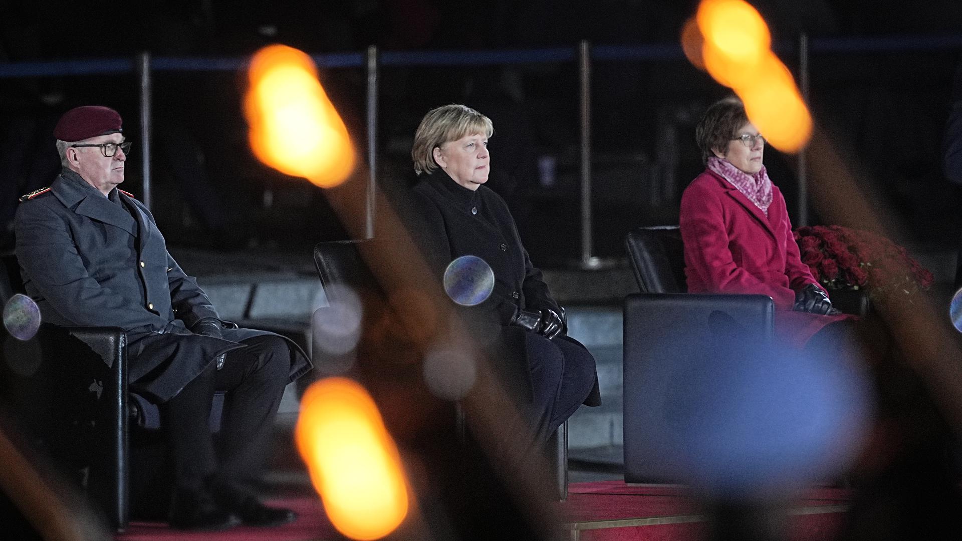 Bundeskanzlerin Angela Merkel sitzt bei ihrer Verabschiedung durch die Bundeswehr zwischen dem Generalinspekteur der Bundeswehr, General Eberhard Zorn, und der Verteidigungsministerin Annegret Kramp-Karrenbauer.