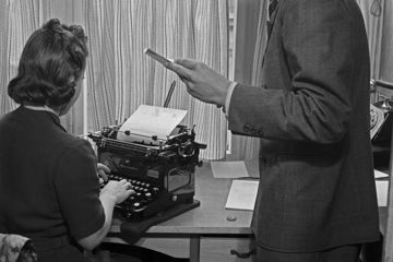 Eine Frau sitzt in den 1940er Jahren an einer Schreibmaschine.