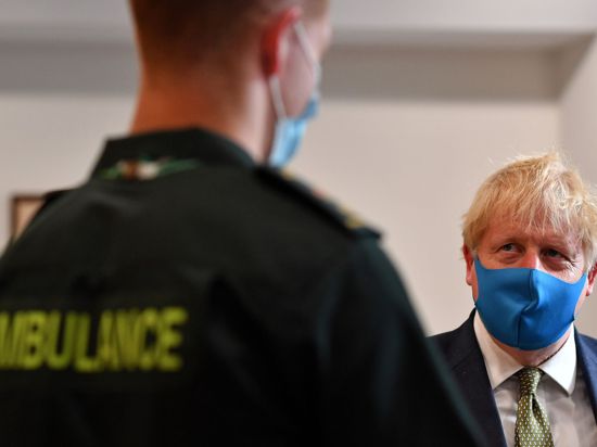 Premier Boris Johnson spricht während eines Besuchs im Hauptquartier des London Ambulance Service NHS Trust mit einem Sanitäter.