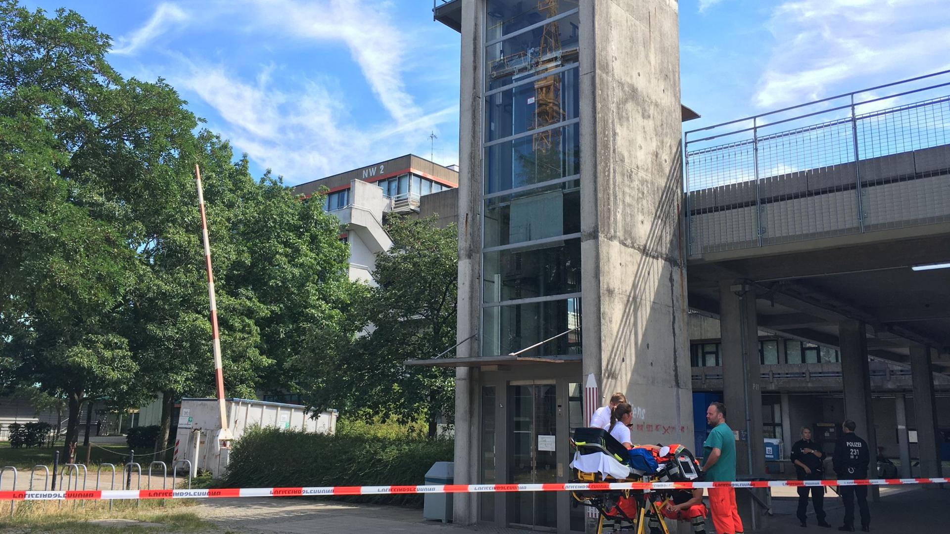 Rettunskräfte und Polizisten stehen auf dem Gelände der Bremer Universität zusammen. In Bremen ist ein Mann nach einer Gewalttat auf das Dach eines Universitätsgebäudes geflohen.