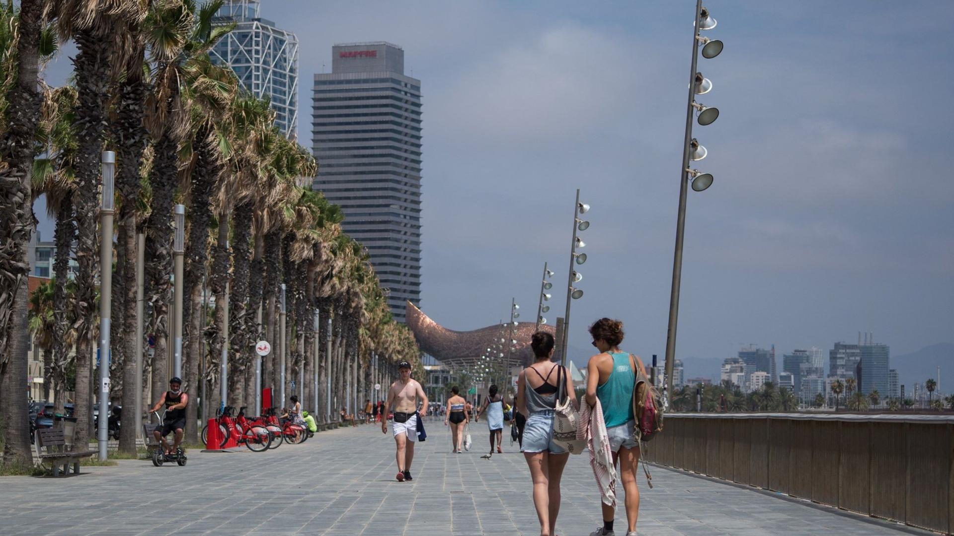 Spaziergänger auf der Strandpromenade in Barcelona.