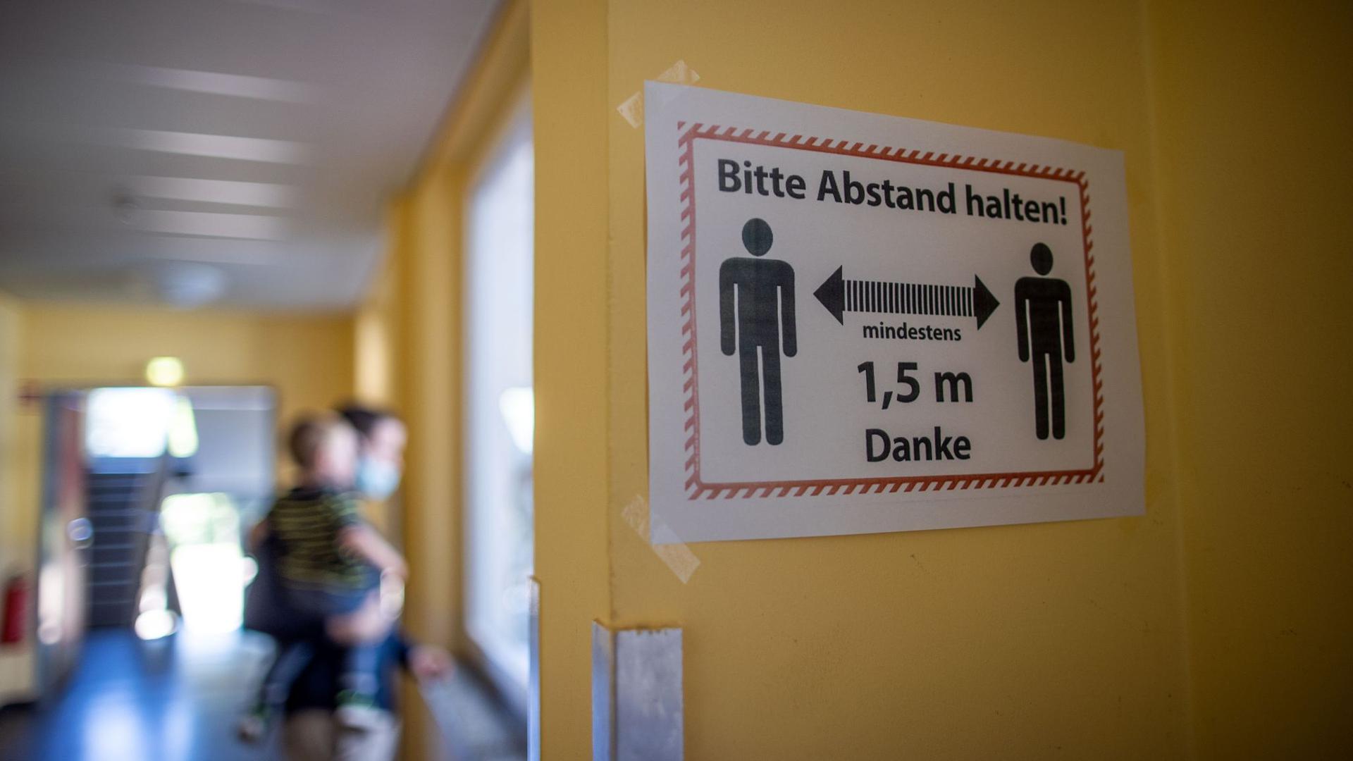 Ein Hinweisschild auf die Sicherheitsabstände hängt in einem Schulflur der Grundschule Lankow.