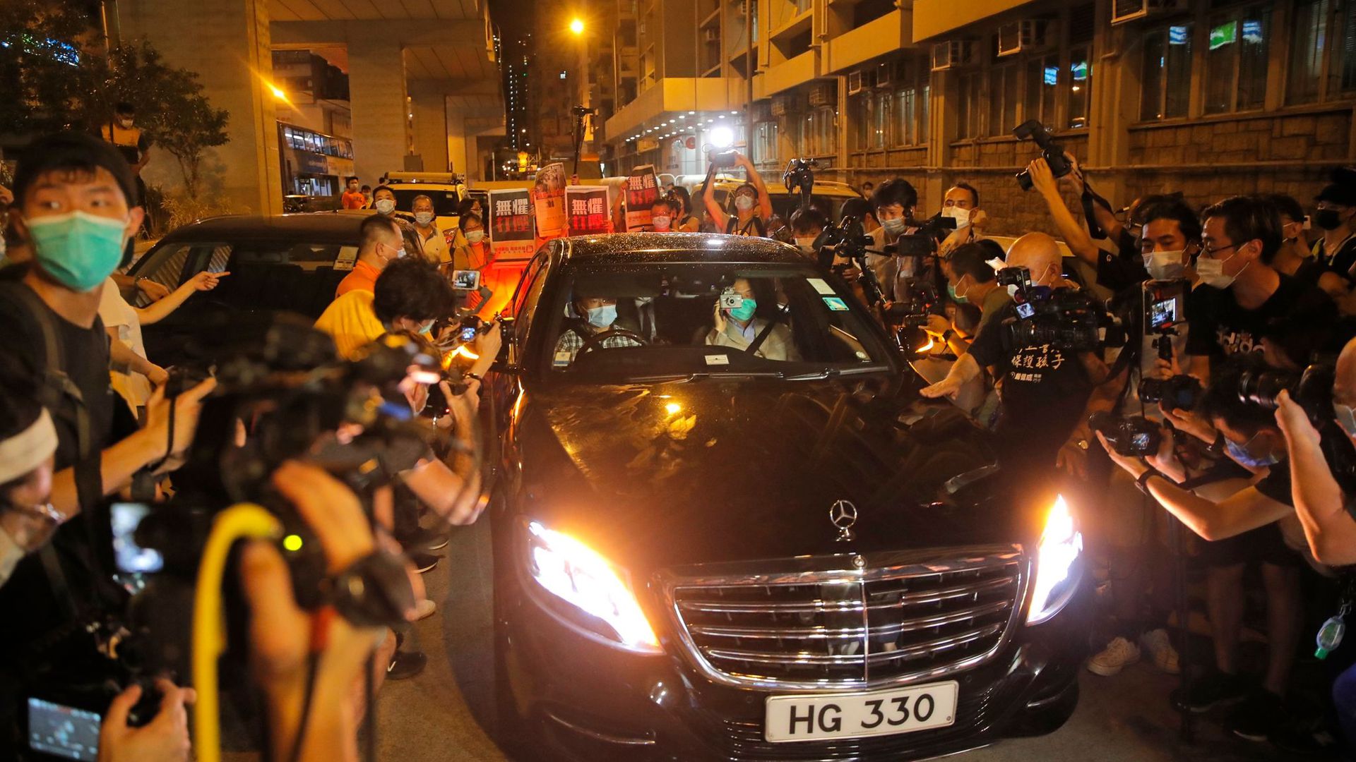 Jimmy Lai (Vordersitz, r) wird beim Verlassen des Polizeireviers von mehreren Dutzend Anhängern der Demokratiebewegung bejubelt.