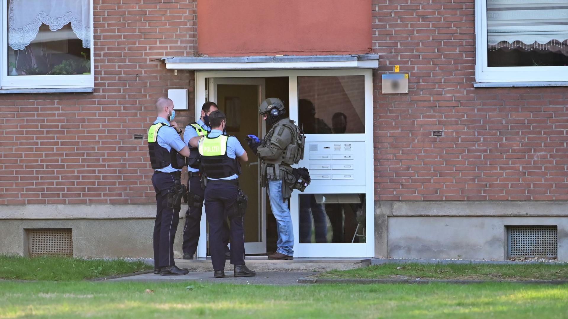 Polizei und ein SEK-Beamte während ihres Einsatzes vor einem Mehrfamilienhauses in Krefeld.