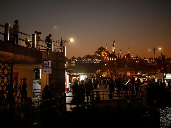 Menschen schlendern vor der Kulisse der Süleymaniye-Moschee am Ufer des Bosporus entlang. Die Zahl der Corona-Fälle in der Türkei steigt weiter an.