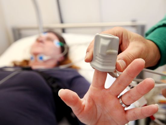Eine Schlafpatientin wird von einem Krankenpfleger im Schlaflabor der Kliniken Essen-Mitte an Elektroden angeschlossen.