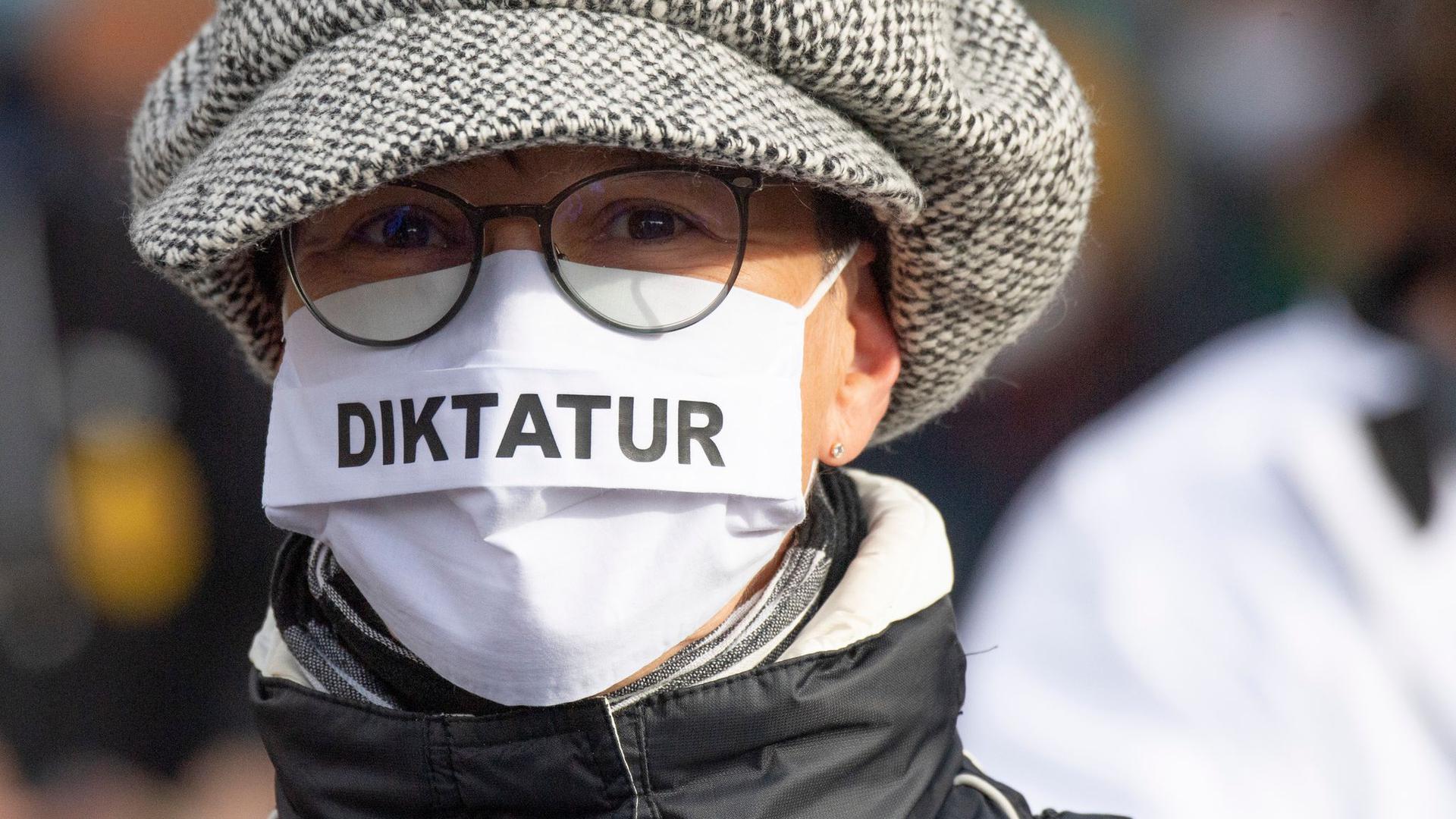 "Diktatur“ steht auf der Nase-Mund-Bedeckung“ einer Teilnehmerin an einer „Querdenken"-Demonstration in Frankfurt am Main.