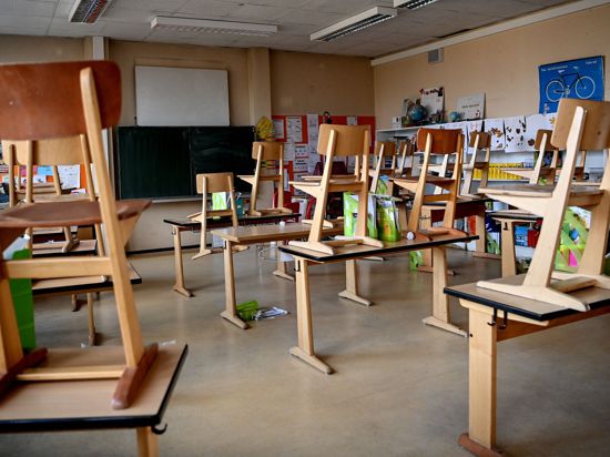 Stühle sind in einem Klassenzimmer hochgestellt.