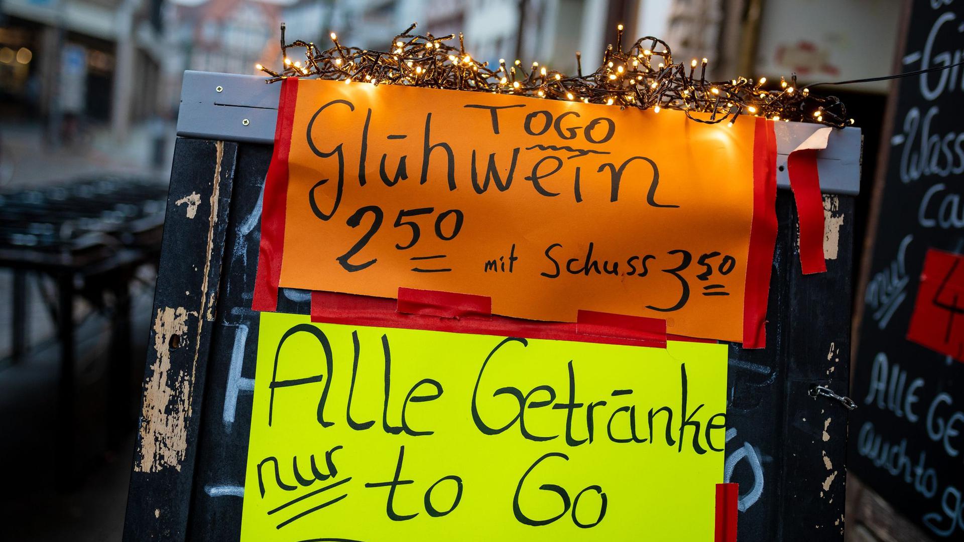 Glühwein „to go“ bewirbt eine Kneipe in der Altstadt in Hannover auf einem Werbeaufsteller.