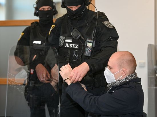 Dem angeklagten Stephan Balliet werden zu Beginn des 24. Prozesstages am 8. Dezember im Saal des Landgerichts die Handfesseln abgenommen.