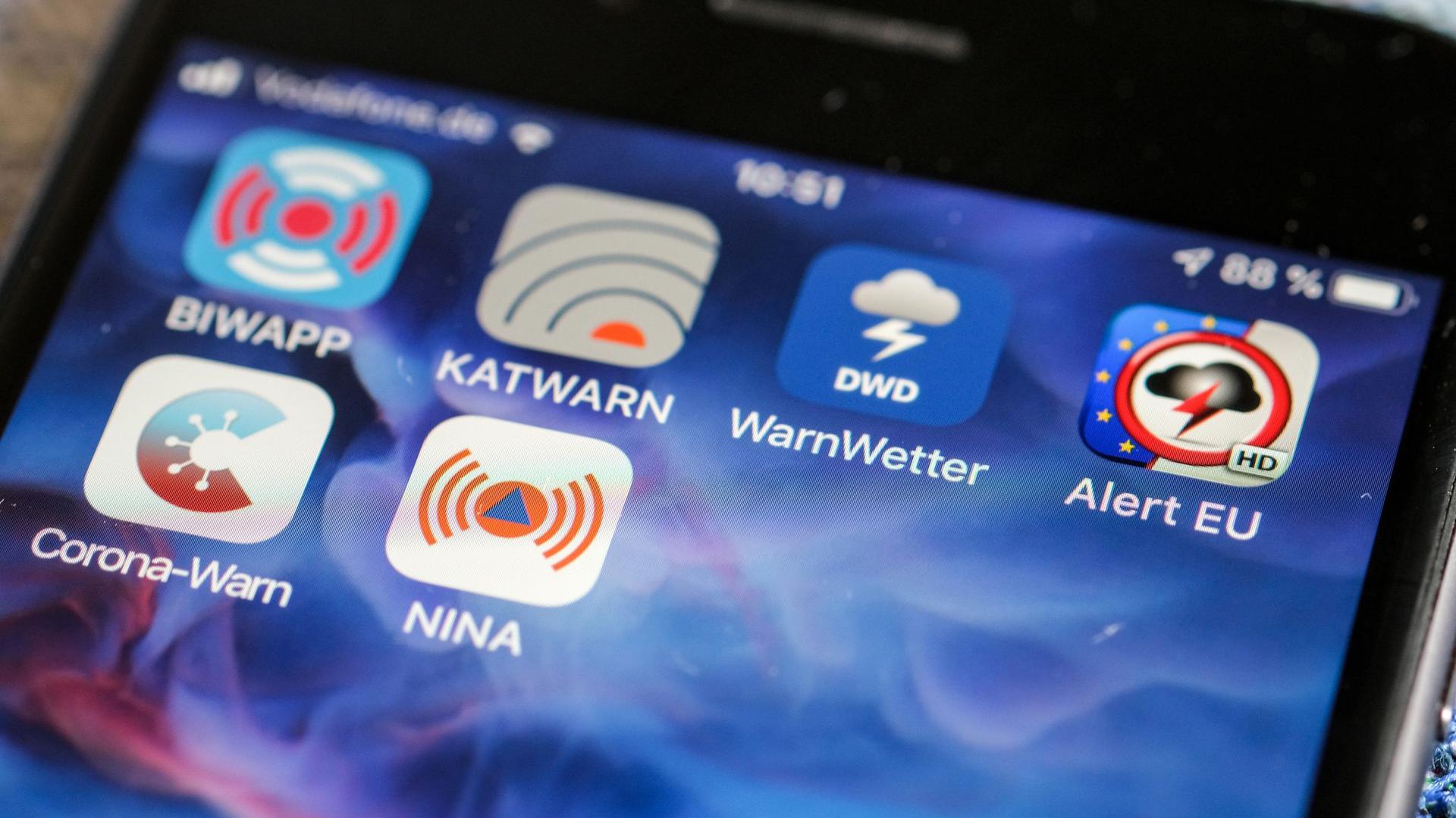 Verschiedene Warn-Apps, darunter die Notfall-Informations- und Nachrichten-App „NINA“ des Bundesamts für Bevölkerungsschutz und Katastrophenhilfe, sind auf einem Smartphone zu sehen.