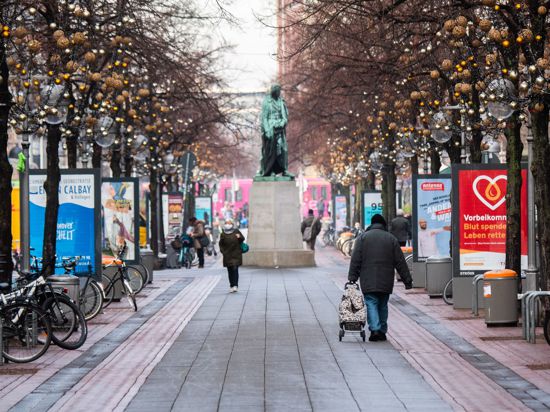 Passanten laufen durch die beinahe menschenleere Innenstadt von Hannover.
