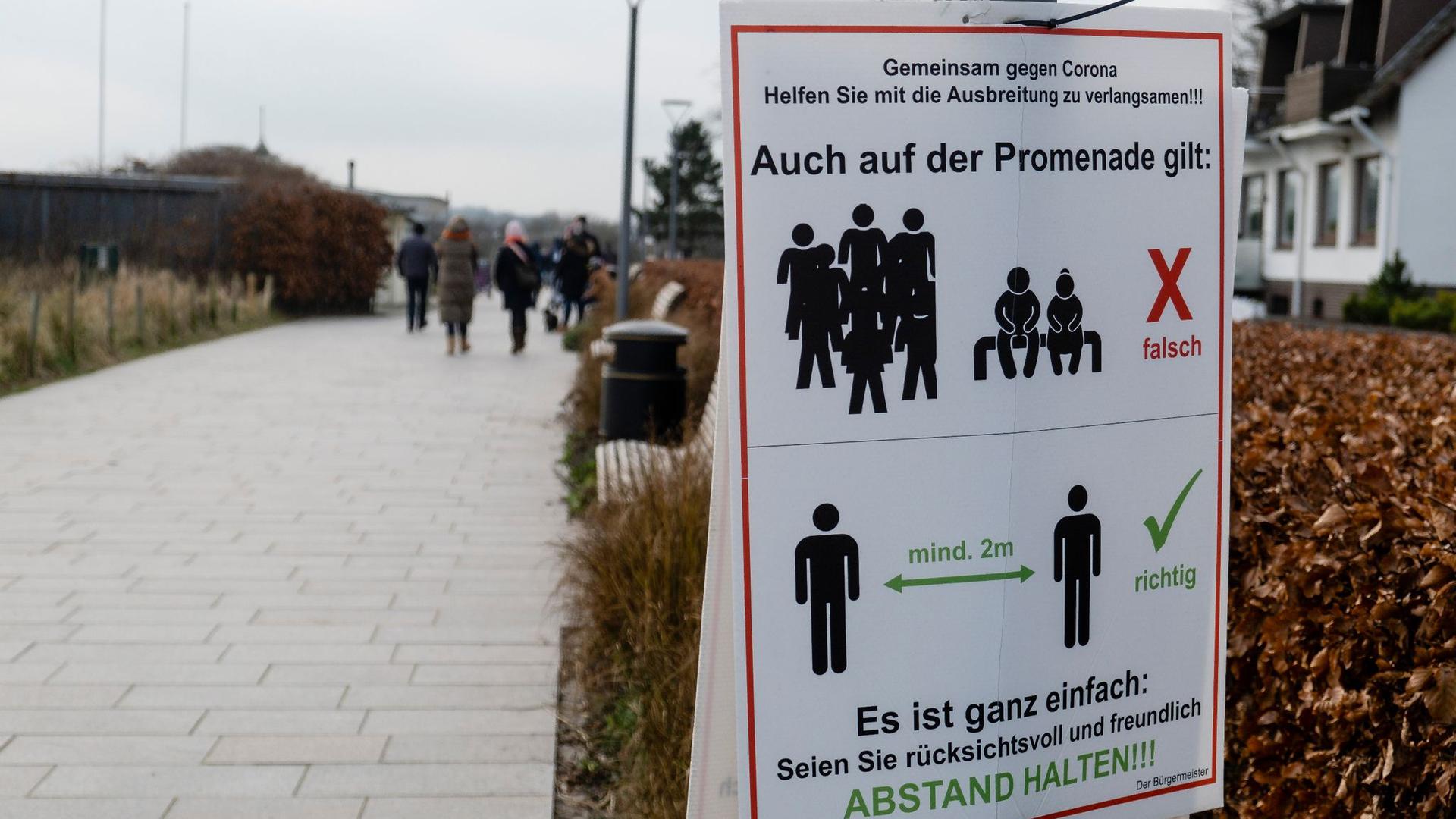 „Gemeinsam gegen Corona“: Ein Schild an einer Promenade weist darauf hin, dass der Abstand eingehalten werden muss.