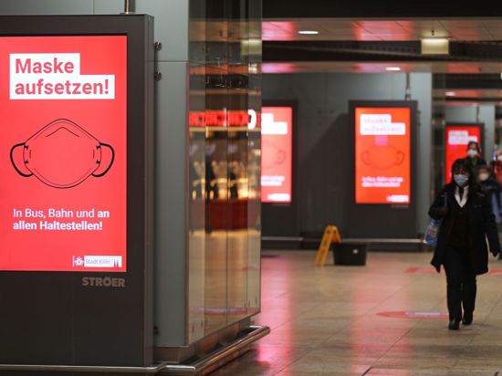 Der Schriftzug „Maske aufsetzten“ steht im Kölner Hauptbahnhof auf einem Display.