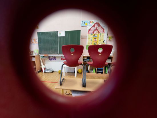 Stühle stehen in einem Klassenzimmer einer ersten Klasse der Marienschule in Stuttgart auf Tischen.