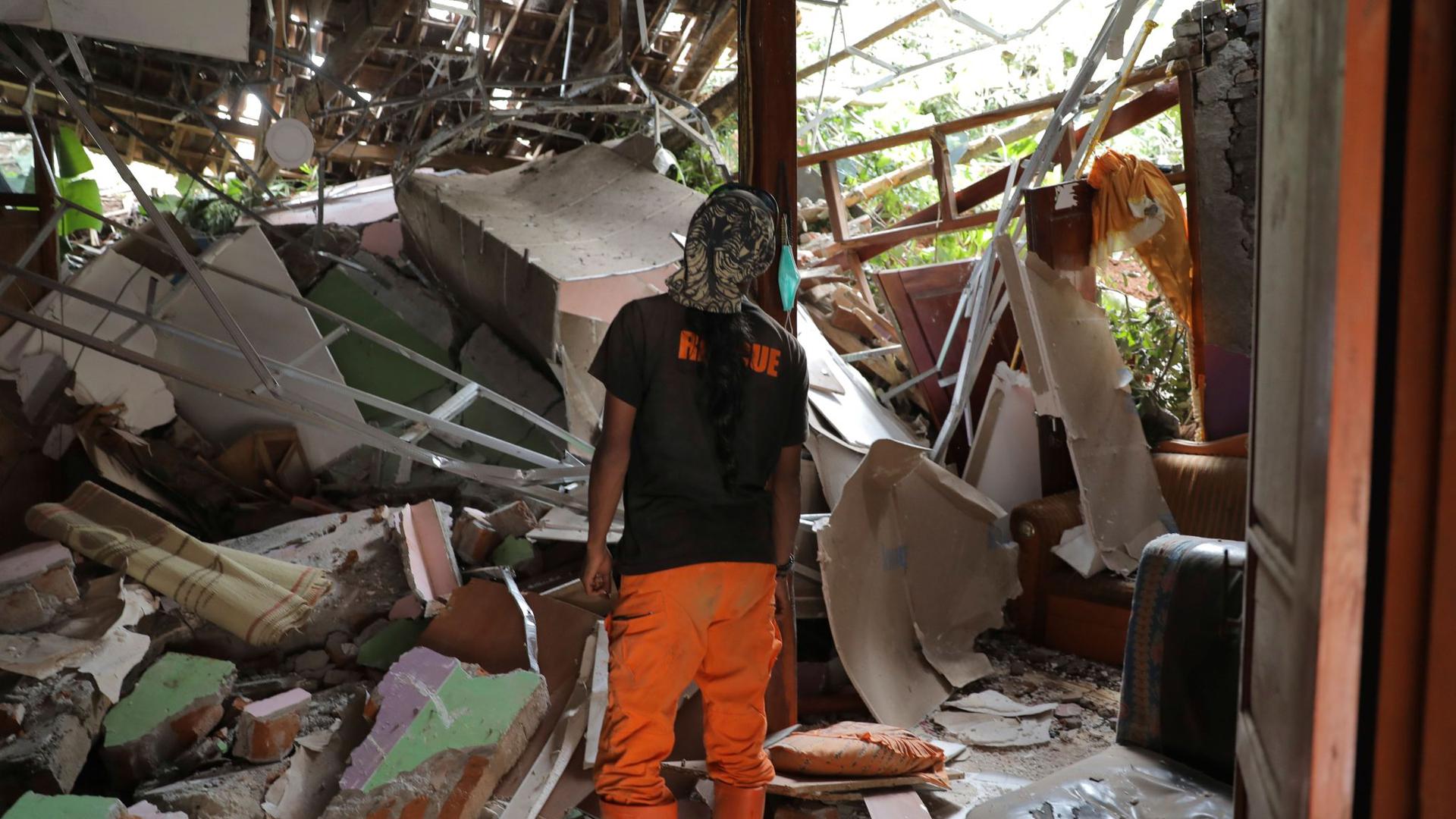 Ein Rettungshelfer inspiziert ein zerstörtes Haus im Dorf Nganjuk.