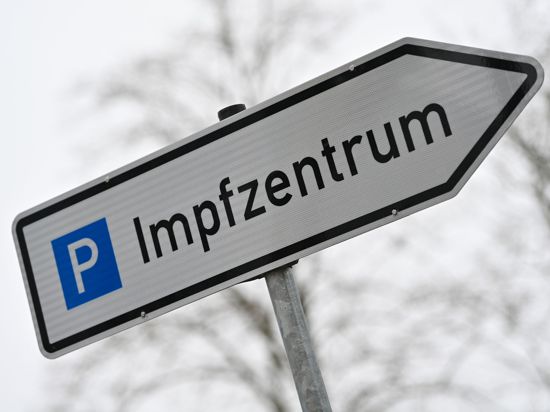 Ein Wegweiser zeigt zum Parkplatz für ein Impfzentrum. In Sachsen sind 2500 Impftermin unbesetzt.