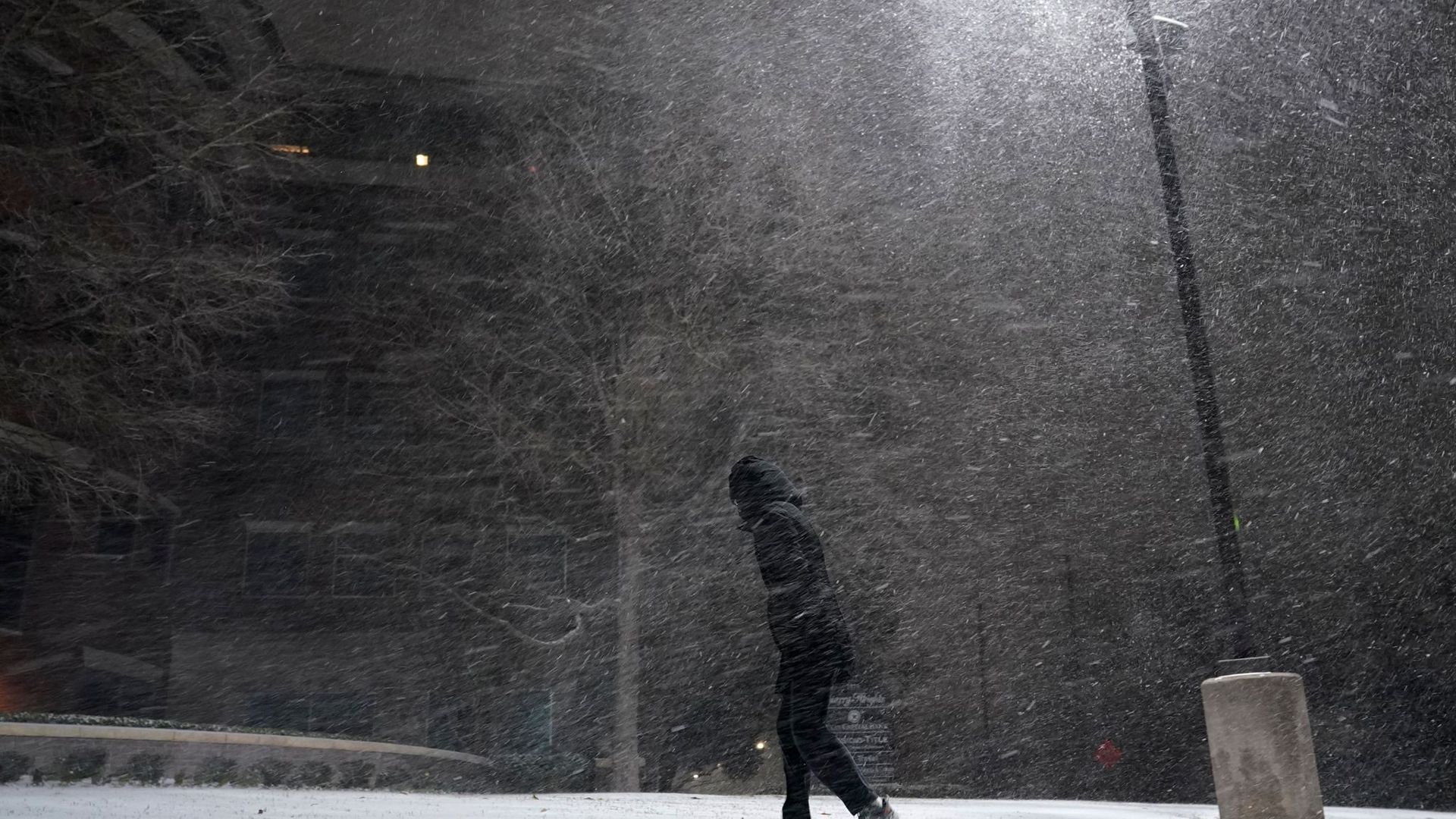 Eine Frau geht im texanischen San Antonio durch den fallenden Schnee.