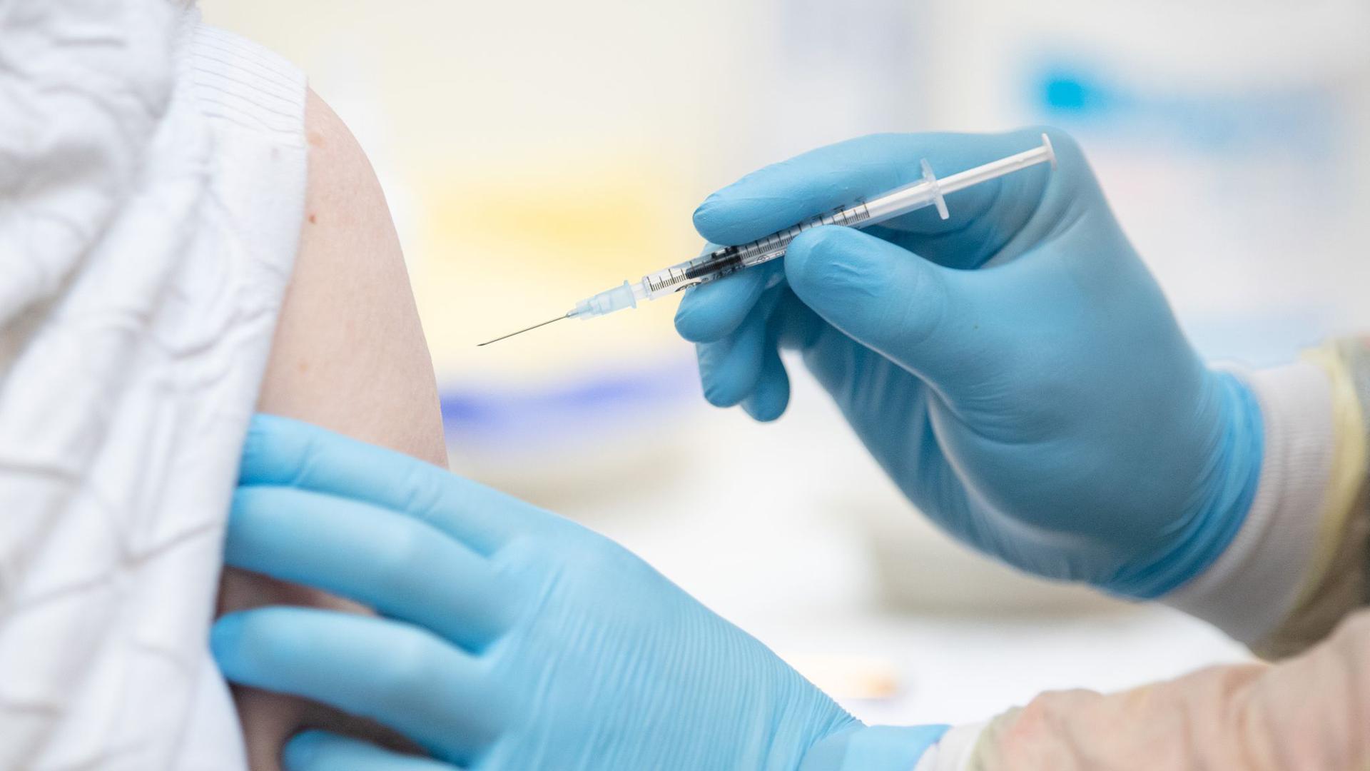 Eine Person wird im Impfzentrum in den Emslandhallen in Lingen mit dem Wirkstoff von Biontech/Pfizer gegen Covid-19 geimpft.