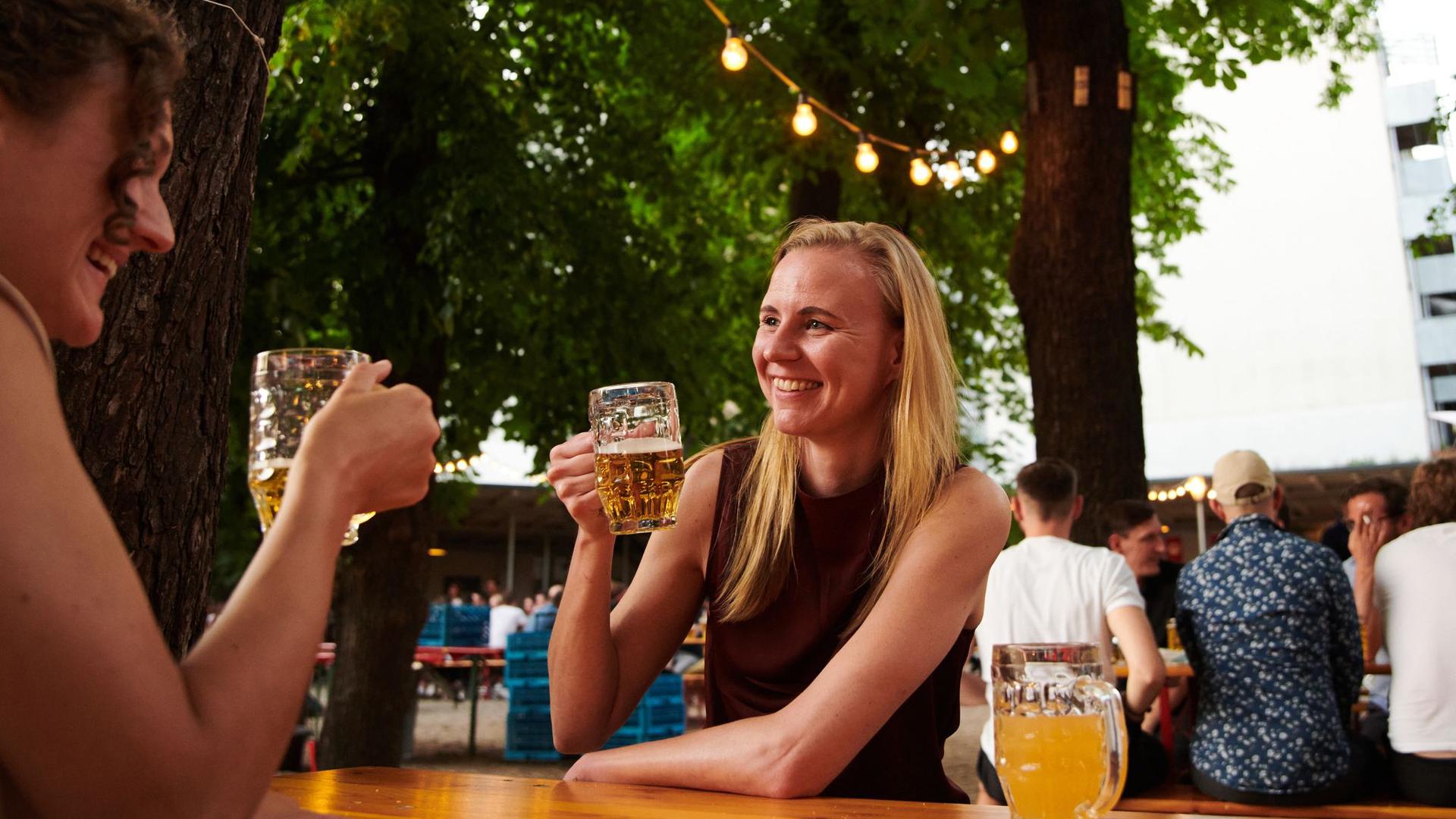 Zwei Frauen trinken ein Bier im Biergarten in Berlin.