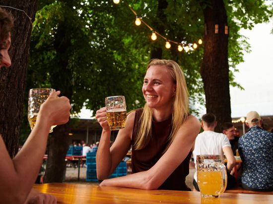 Zwei Frauen trinken ein Bier im Biergarten in Berlin.