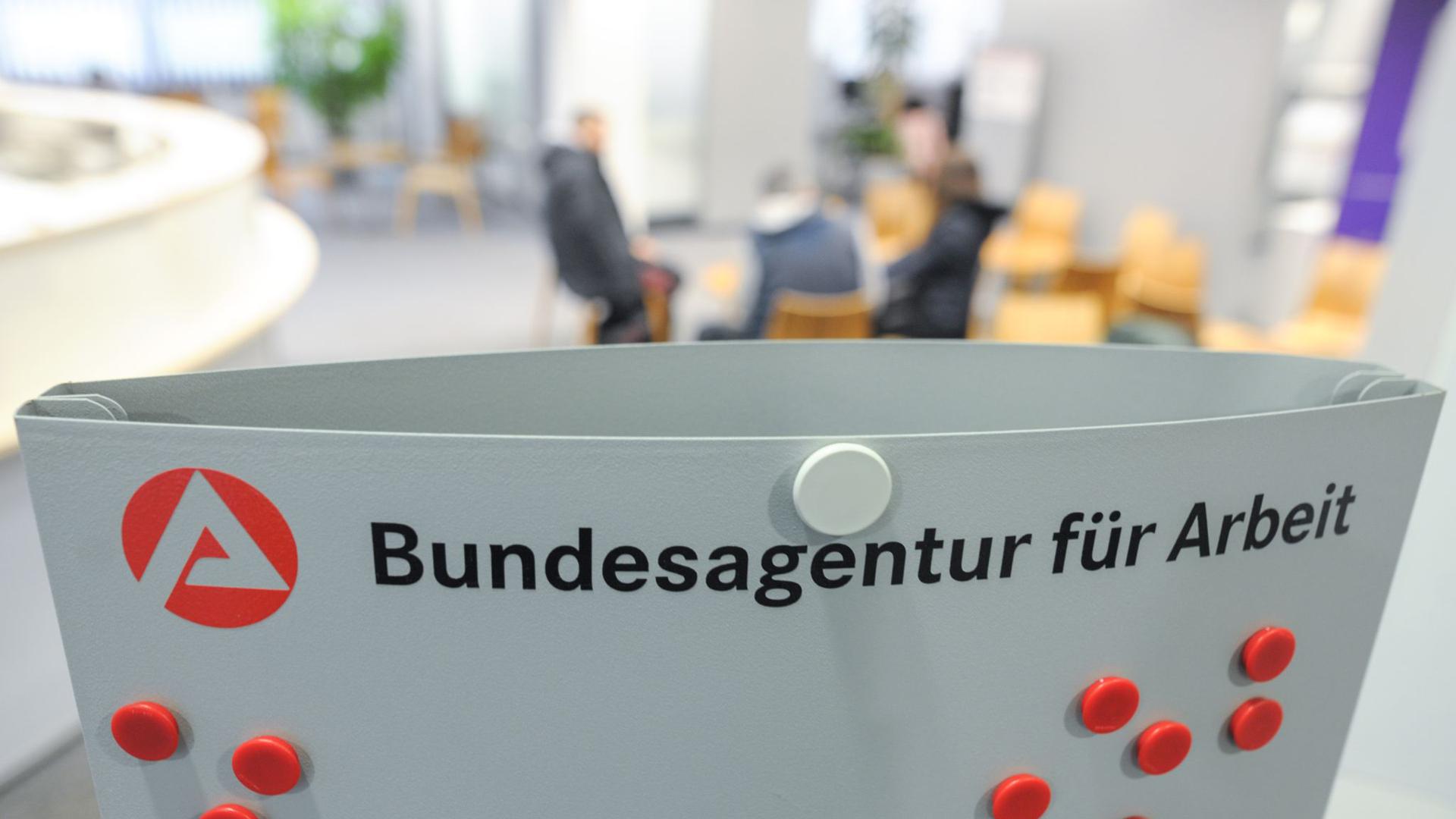 Mehrere Personen sitzen im Wartebereich der Bundesagentur für Arbeit in Stuttgart.