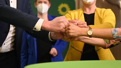 Mitglieder und Anhänger von Bündnis 90/Die Grünen bringen ihre Fäuste zusammen nach der Bekanntgabe der ersten Prognose zum Ergebnis der Landtagswahlen in Baden-Württemberg.
