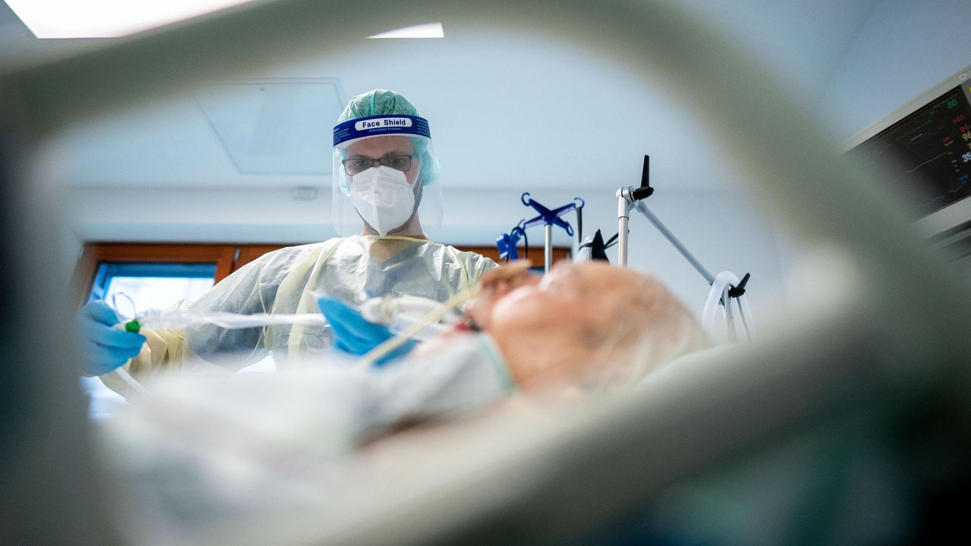 Zerreißprobe: Ein Pfleger versorgt in Schutzausrüstung auf der Intensivstation einen Corona-Patienten. Die neue Welle trifft das nach einem Pandemie-Jahr erschöpfte Klinikpersonal.