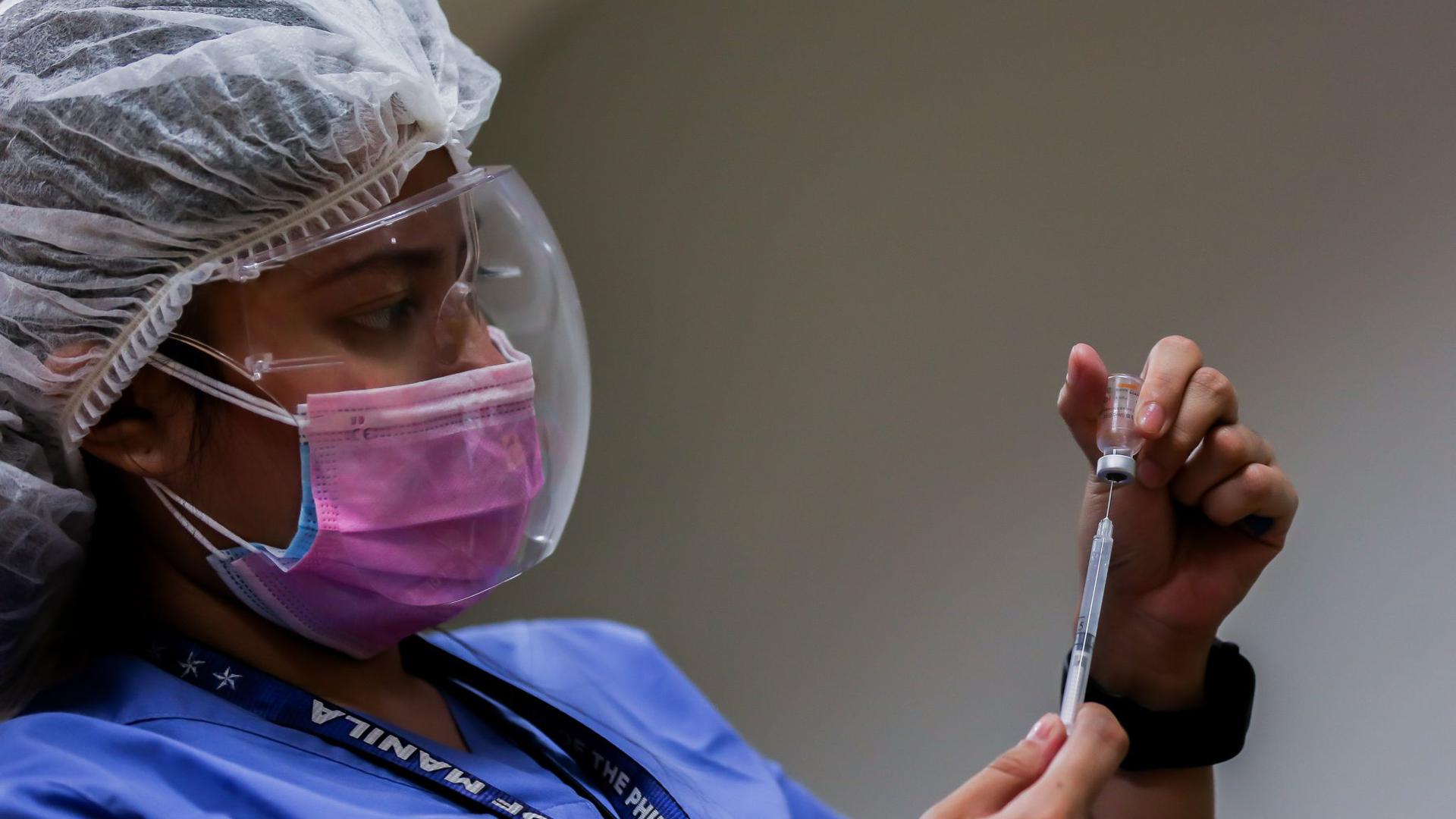 Eine medizinische Mitarbeiterin bereitet auf den Philippinen eine Impfung vor.