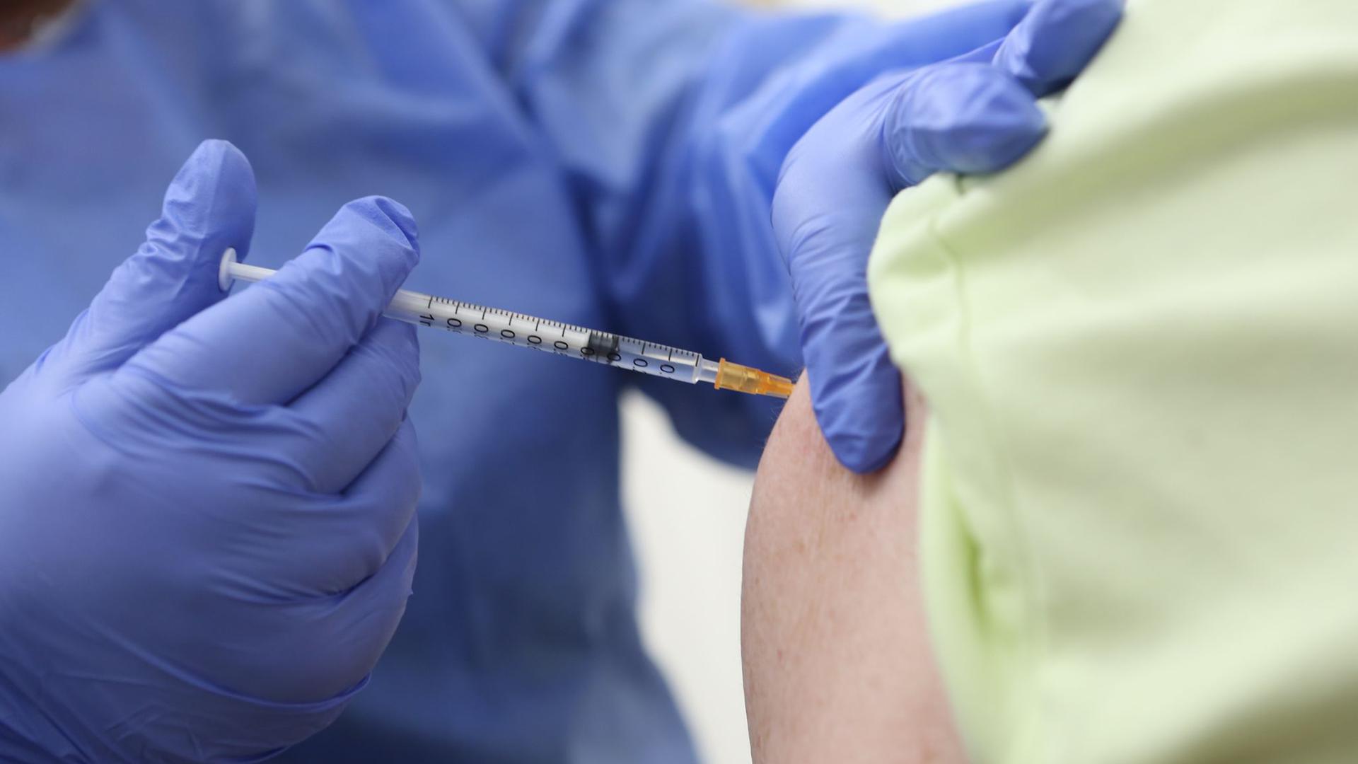 Eine achtzigjährige wird in einem Impfzentrum gegen das Coronavirus geimpft.