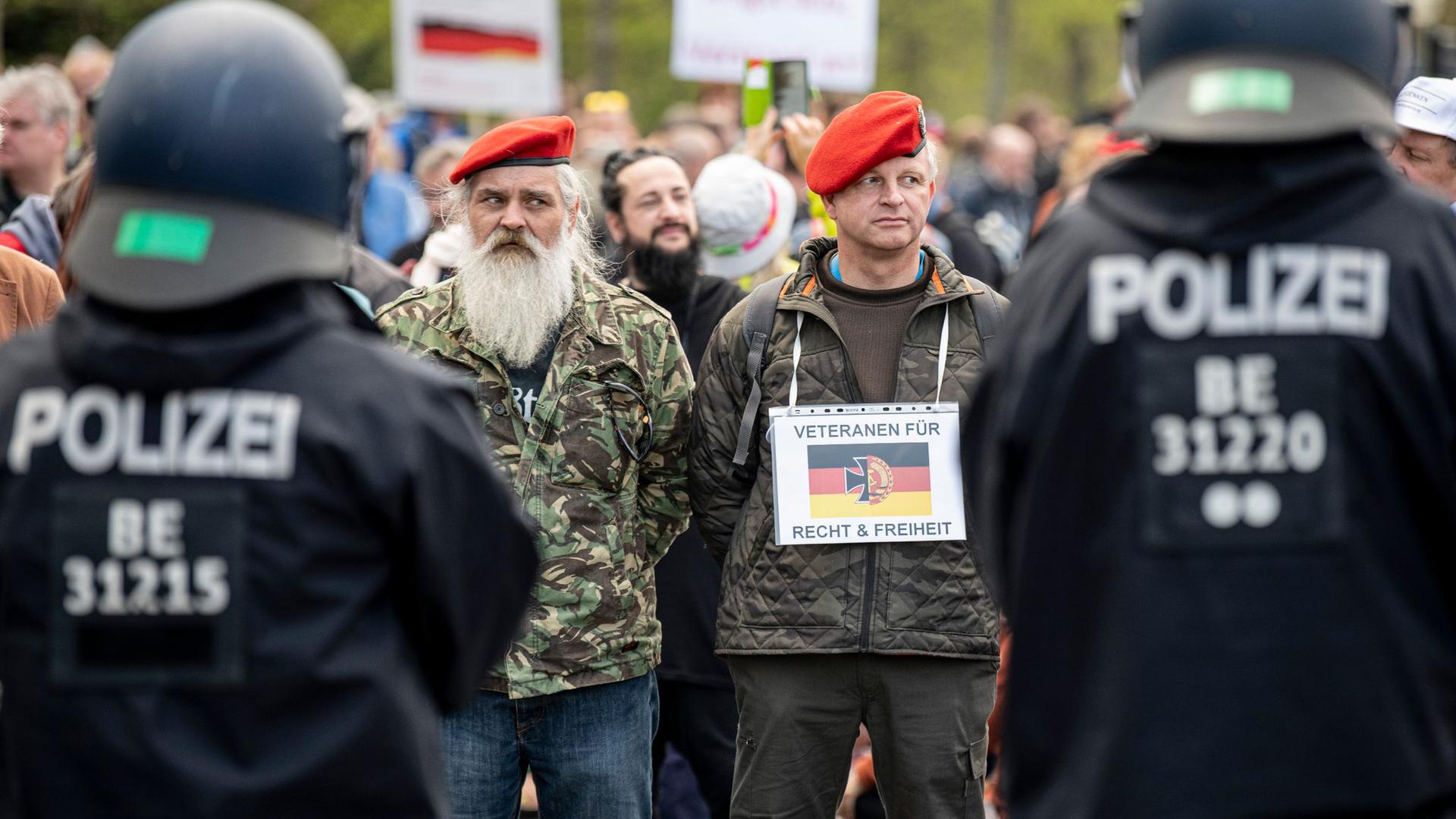 Zwei Demonstranten stehen mit einem Schild - „Veteranen für Recht und Freiheit“ - auf der Straße des 17. Juni in Berlin.