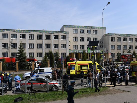 Einsatzkräfte von Polizei und Rettungsdiensten stehen vor einem Gymnasium. Bei einem Angriff auf die Schule sind mehrere Menschen getötet worden.