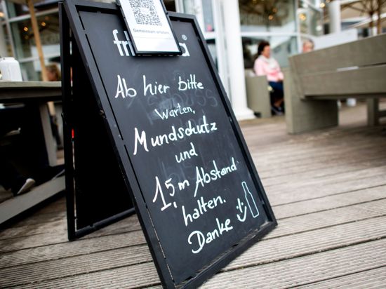 „Mundschutz und 1,5 m Abstand halten“ steht auf einem Schild vor einem Lokal auf der Nordseeinsel Norderney. Niedersachsen öffnet den Tourismus zunächst nur für die Einwohner des eigenen Bundeslandes.