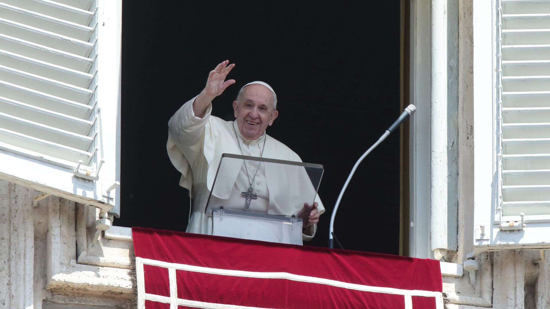 Papst Franziskus winkt vom Fenster mit Blick auf den Petersplatz.
