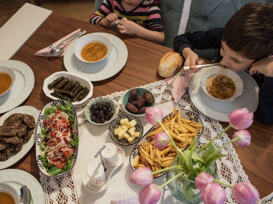 Kinder und Eltern nehmen während des heiligen Fastenmonats Ramadan ein gemeinsames Fastenbrechen-Essen in ihrer Wohnung ein.
