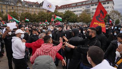 Teilnehmer einer pro-palästinensische Demonstration stehen auf dem Marienplatz in Stuttgart. Am Rande der Kundgebung kam es zu Rangeleien zwischen unterschiedlichen Gruppen und zwischen Demonstranten und der Polizei.