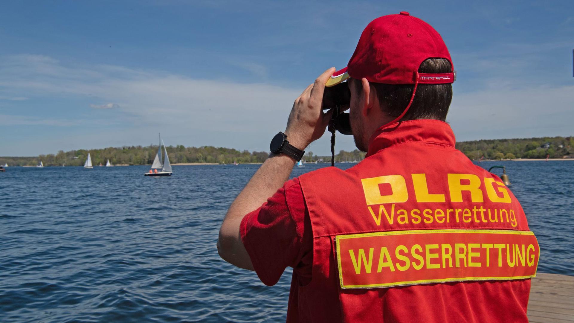 Ein Mitglied der Deutschen Lebensrettungs-Gesellschaft (DLRG) beobachtet die Boote auf dem Wannsee.