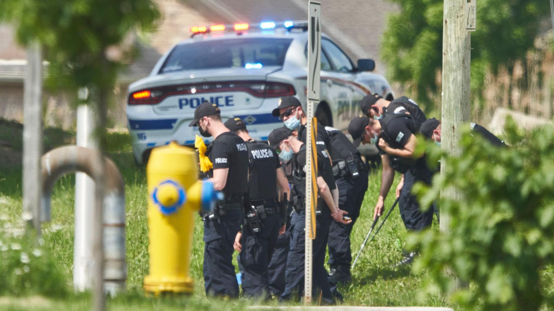 Polizisten in Reihe untersuchen den Tatort eines Autounfalls in London, Ontario. Nach einem Angriff mit einem Auto, bei dem vier Menschen aus einer muslimischen Familie getötet worden sind, geht die Polizei Berichten zufolge von einem rassistischen Tatmotiv aus.