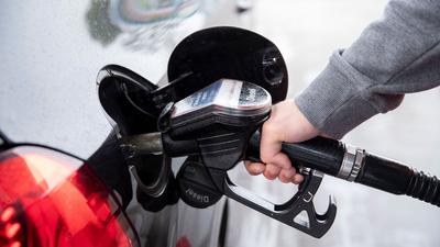 Ein Autofahrer steckt an einer Tankstelle einen Zapfhahn in die Tanköffnung seines Fahrzeugs. Für Kraftstoffe und Heizöl mussten Verbraucher zuletzt deutlich tiefer in die Tasche greifen als ein Jahr zuvor.