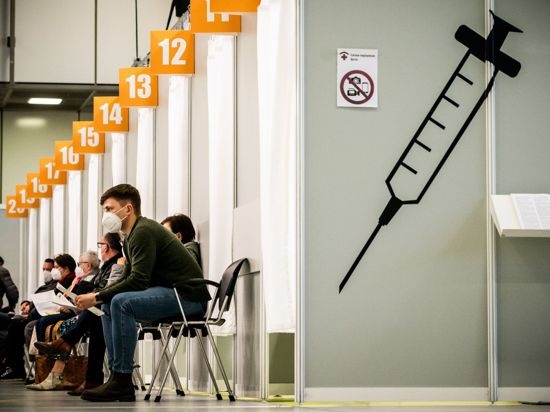 Menschen warten im Corona-Impfzentrum auf dem Berliner Messegelände auf ihre Impfung. Mehrere Politiker fordern eine Strafe für Impfterminschwänzer.