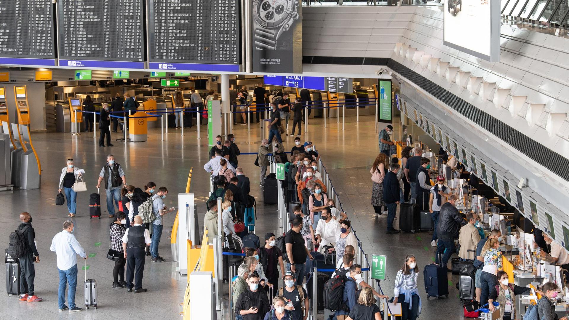 Flugpassagiere stehen an den Check-In Schaltern im Terminal 1 des Flughafens in Frankfurt.