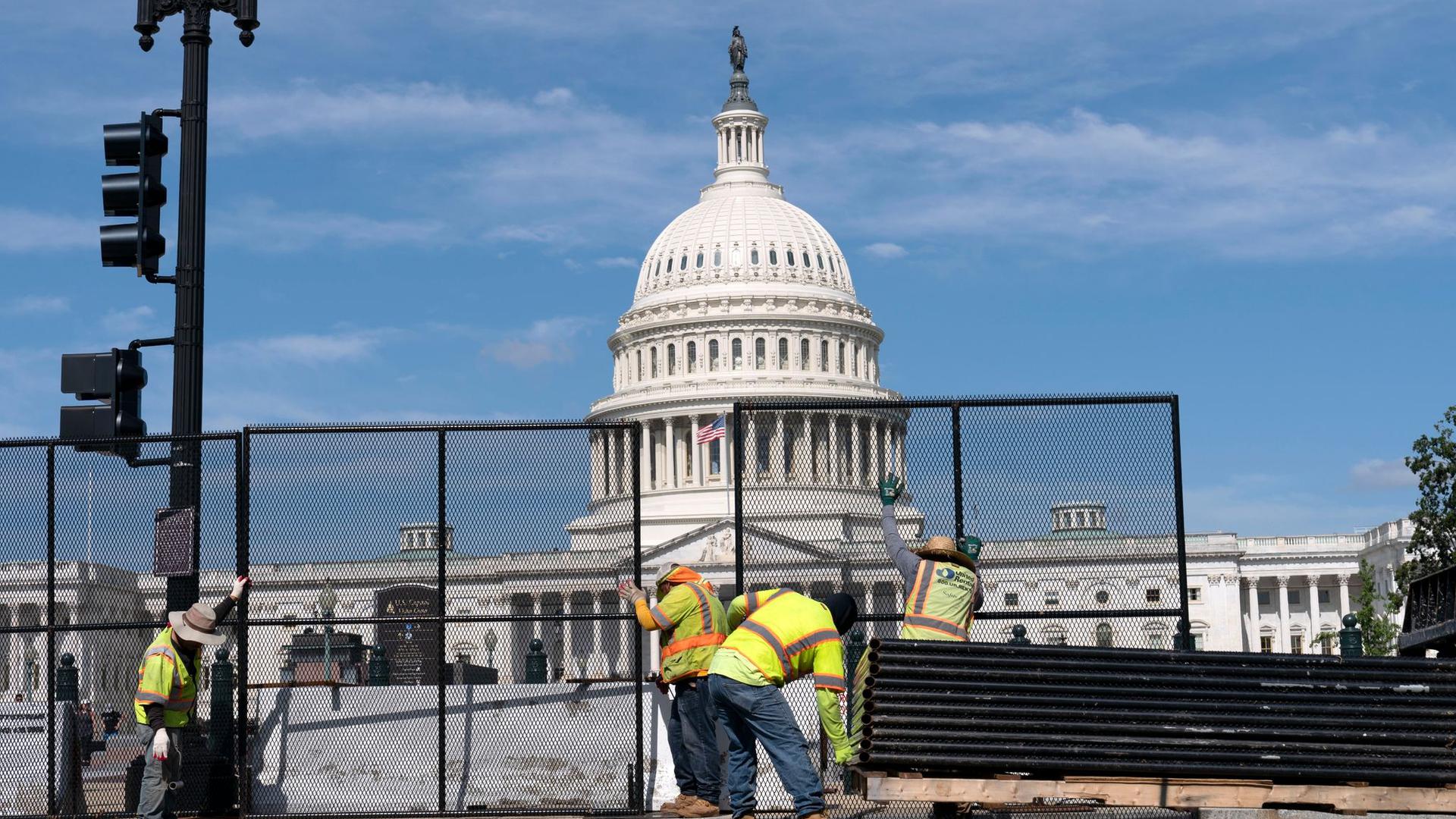 Arbeiter entfernen den Schutzzaun am Kapitol, der nach dem Sturm am 06.01.2021 auf den Parlamentssitz durch Anhänger des damaligen US-Präsidenten Trump errichtet worden war.